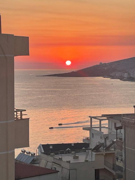 a sunset over a body of water with the sun setting at Honey Residence in Sarandë