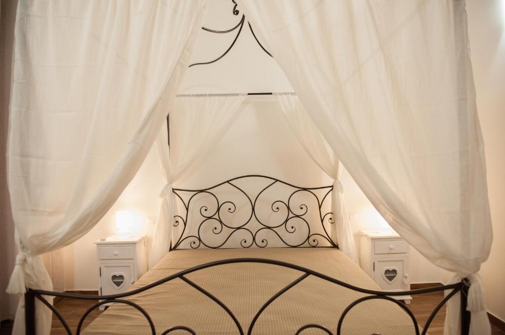 トラーパニにあるcampo appartamentiのベッドルーム(白いカーテン付きのベッド1台付)