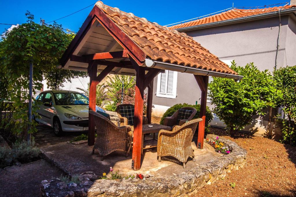 a wooden gazebo with chairs in front of a house at Apartman Joso in Diklo