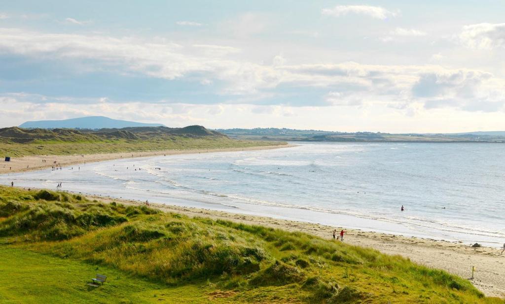 una playa con gente caminando por la arena en Enniscrone Apartment, en Enniscrone