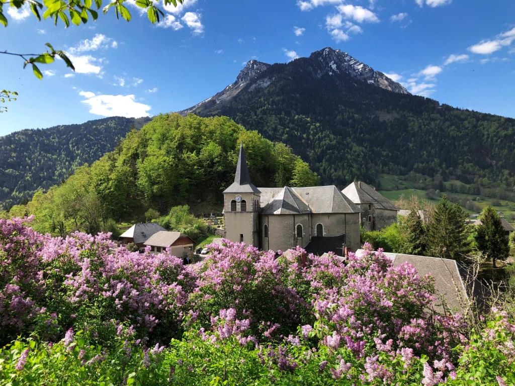 an old church with a mountain in the background at La compagnie du bourg in Le Châtelard