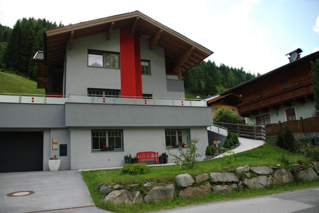 a house with a red stripe on the side of it at Ferienwohnung Kendler in Hüttschlag