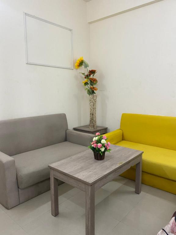 a living room with two couches and a table with flowers at Urban Stays in Ghaziabad
