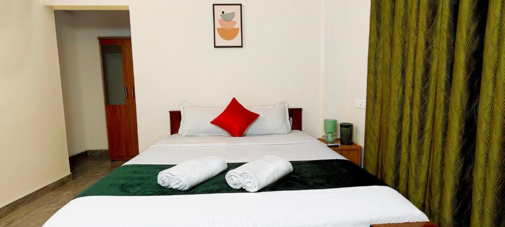 WayanadRhythm Residency Wayanad的卧室里有一张大床，配有红色枕头