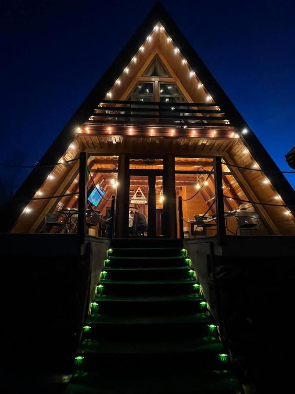 a house with lights on the stairs at night at Casuta din LAZ in Onceşti