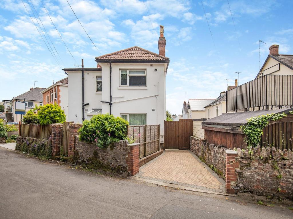 a white house with a gate and a fence at Leehaven in Torquay