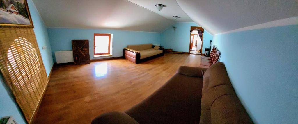 sala de estar con paredes azules y sofá en Дом у моря, en Chornomorsk