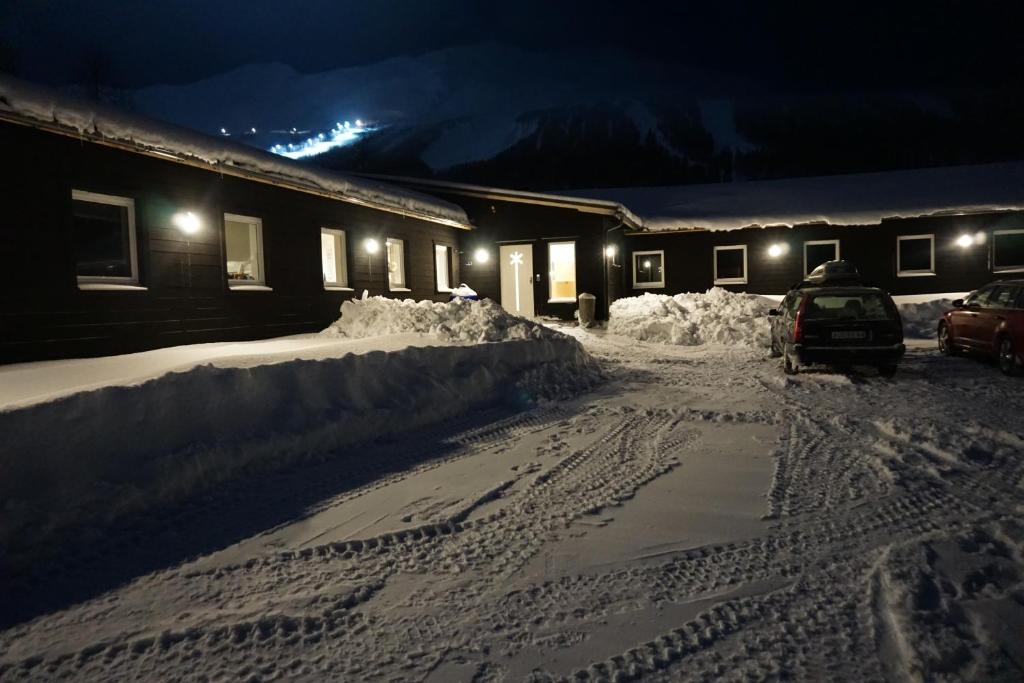 une maison est couverte de neige la nuit dans l'établissement Kittelfjäll Vandrarhem, à Kittelfjäll