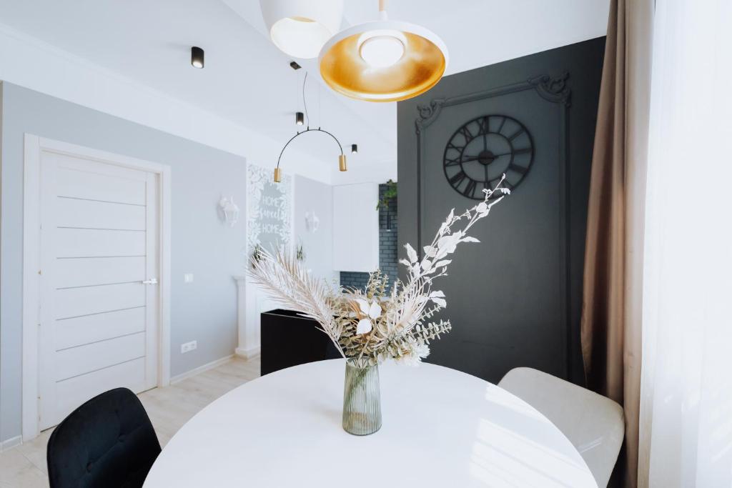 a dining room with a white table with a vase of flowers at Top-floor 1BR Full equipped in Riscani Chisinau in Chişinău