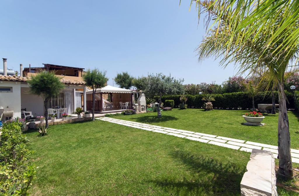 a yard with a house and a palm tree at Kamarina Land in Santa Croce Camerina