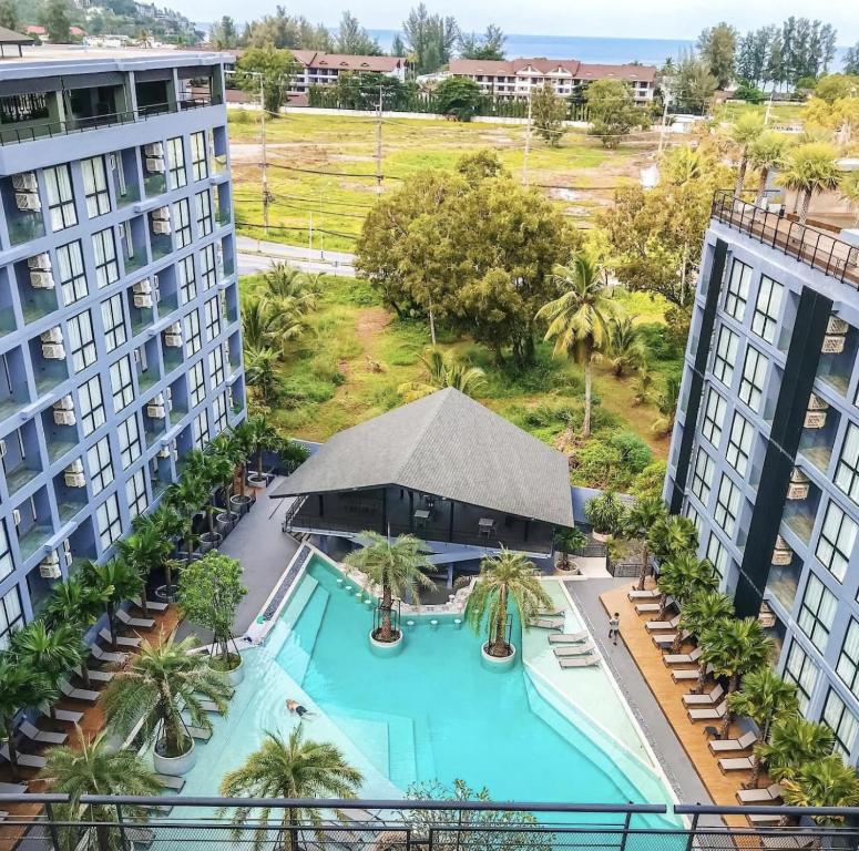 an aerial view of a pool with palm trees and buildings at Oasis in CityGate 1BR Suite in Kamala Beach