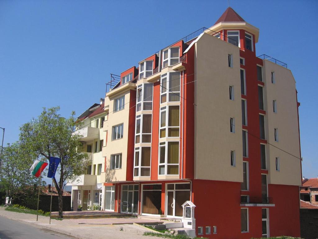 a red and white building on the side of a street at Hotel Deva in Sandanski