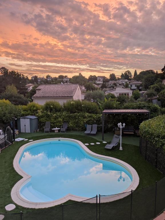- une piscine dans une cour avec un coucher de soleil dans l'établissement Bas de villa composée d'un 3 pièces et d'un studio avec piscine privée, à Villeneuve-Loubet