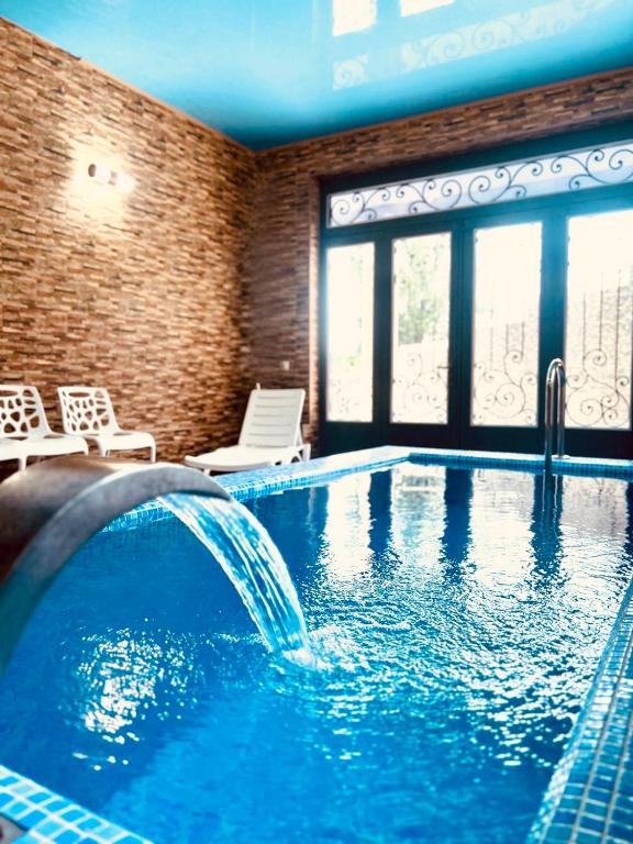 a swimming pool with a waterfall in a hotel room at Green villa panorama in Batumi