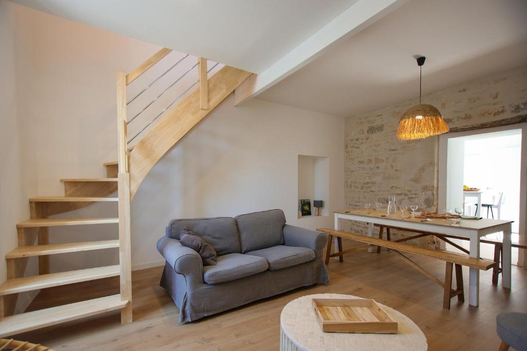 un salon avec un canapé et un escalier dans l'établissement Aux Trois Mousquetaires - proche Jardin Dumaine, à Luçon