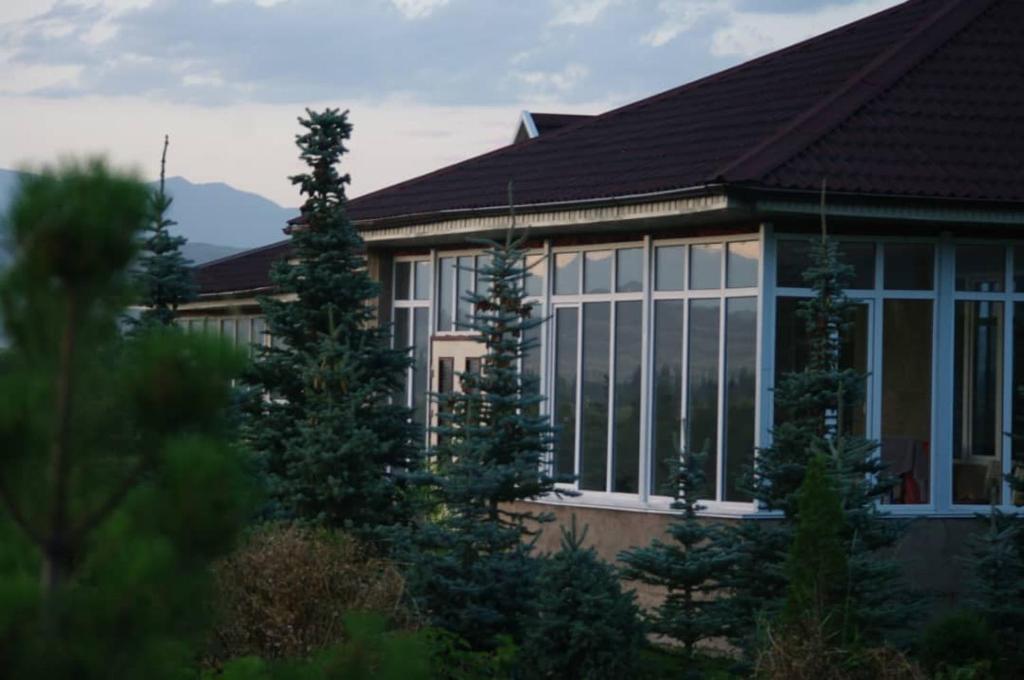a house with large windows and trees in front of it at Кара суу in Akchiy