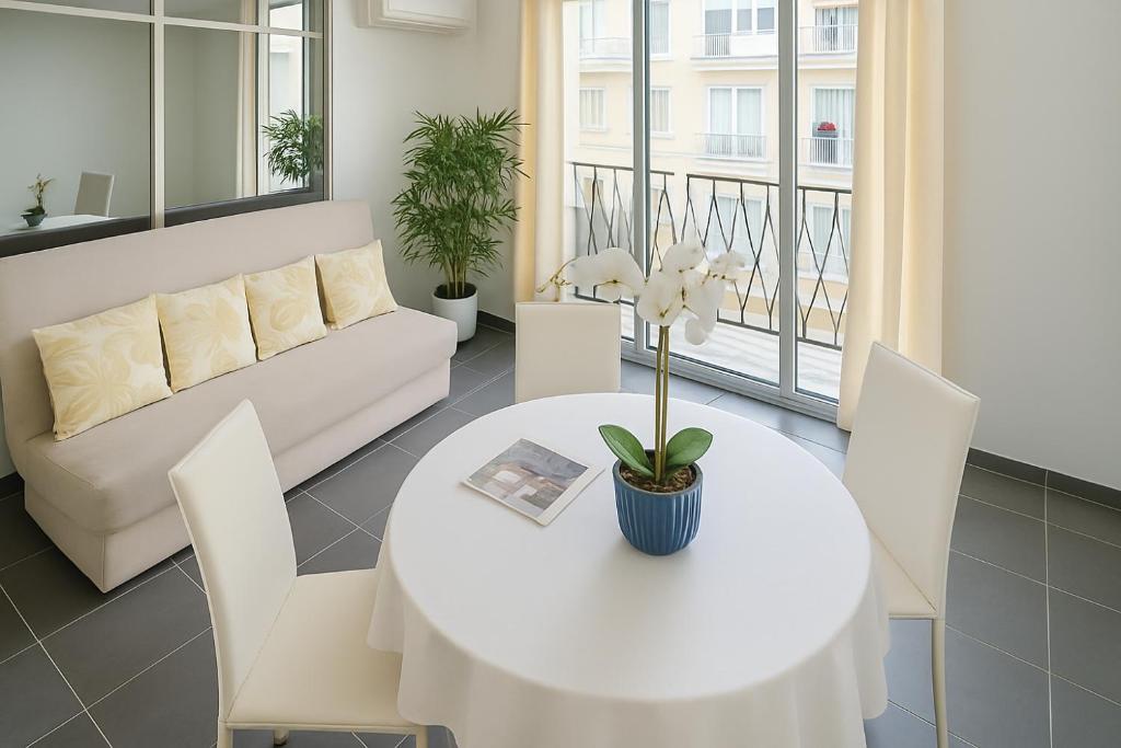 un salon avec une table et des chaises blanches dans l'établissement Le Monte Carlo, à Antibes