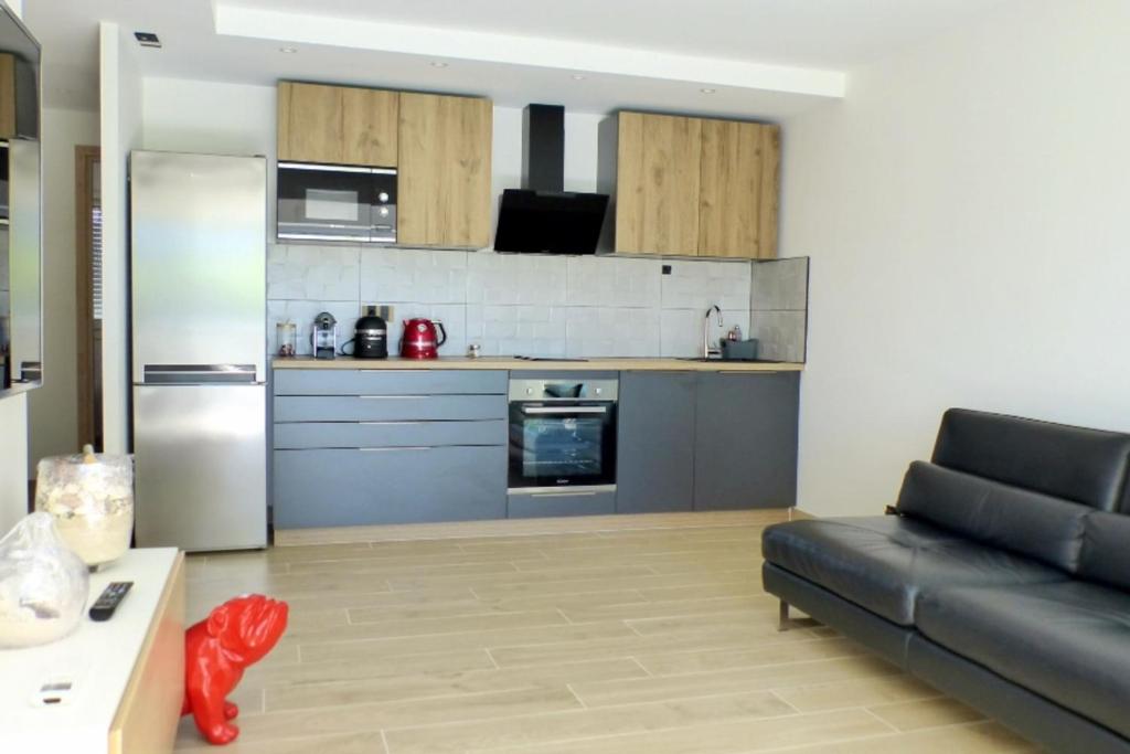 un salon avec un canapé et une cuisine dans l'établissement Apartment with garden 200 m from the beach, à Sanary-sur-Mer