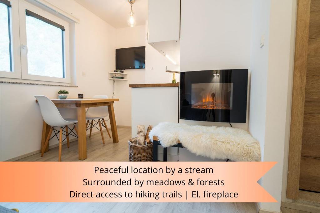 un soggiorno con camino e tavolo di Apartment Loyd, Kranjska Gora - studio a Kranjska Gora