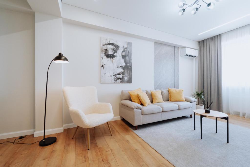 Una sala de estar con un sofá blanco y una silla. en 1BR - Workspace - Park View - Elevator, en Chişinău