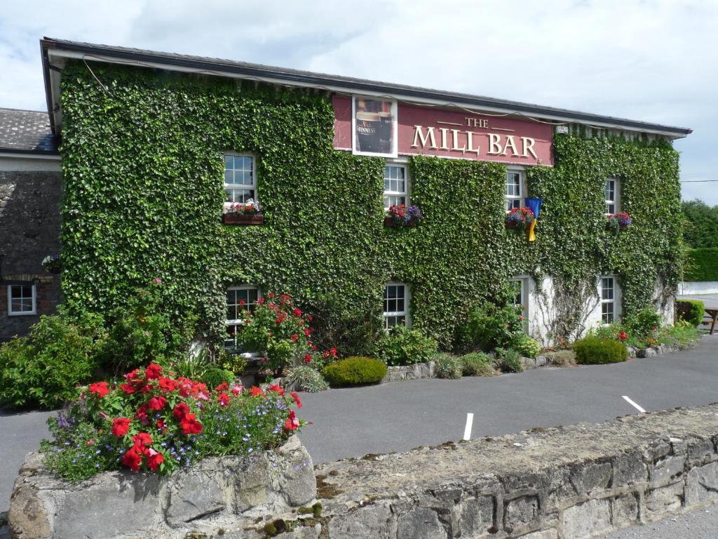 a building covered in green ivy with a million bar sign at The Mill Bar in Athlone