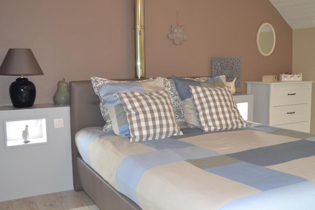 um quarto com uma cama com almofadas em Gite les Estinnes em Estinnes-au-Mont