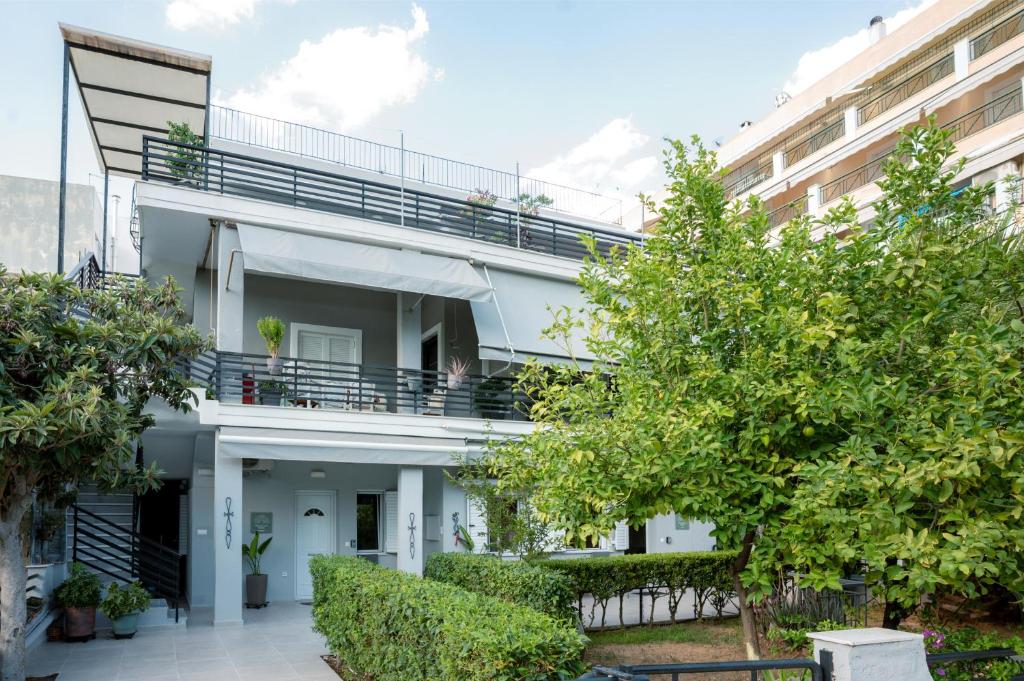 an apartment building with a balcony and trees at Peacock's Apartments in Piraeus
