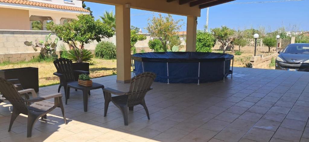 a hot tub on a patio with chairs and a table at Casa vacanza Il Melograno in Santa Maria Del Focallo