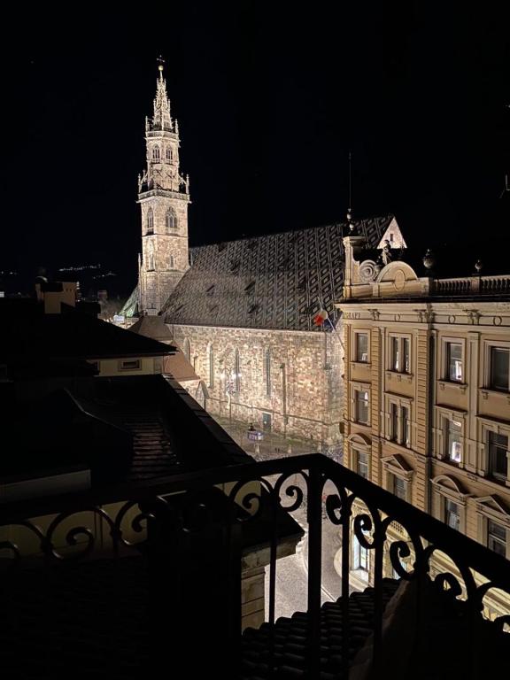 a view of a building with a clock tower at night at Sunflower House in Bolzano