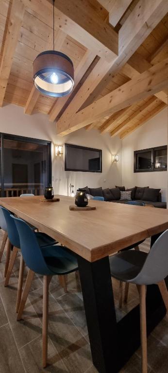 ein Esszimmer mit einem Holztisch und blauen Stühlen in der Unterkunft Appart 3 pièces Cosy - idéal famille & sports Le Cairn De Samoëns in Samoëns