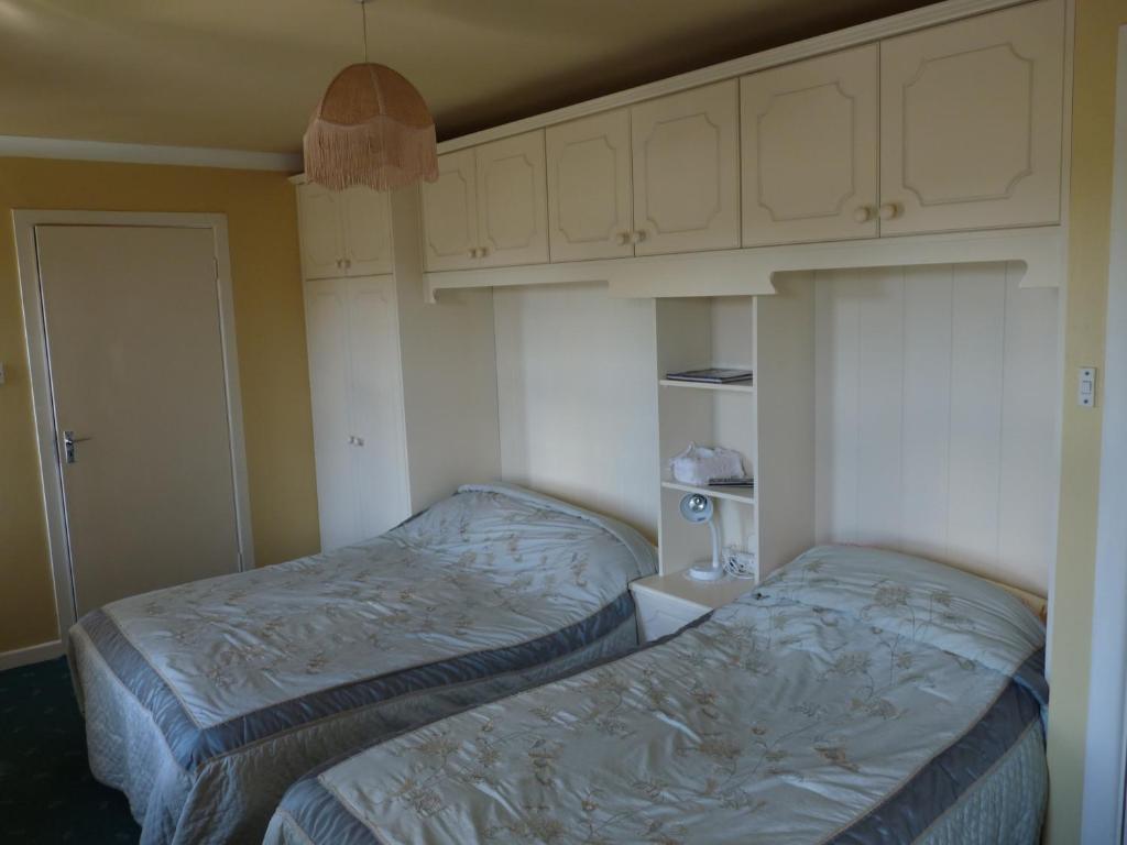 a bedroom with two beds and white cabinets at The Mill Bar in Athlone