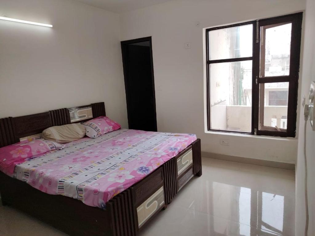 a bedroom with a bed and a window at Poonam's Nest in Faridabad