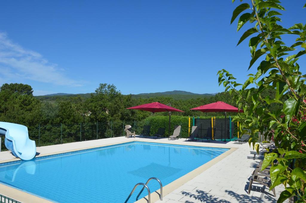 une piscine avec chaises et parasols dans l'établissement Domaine d'Augnac, à Rosières