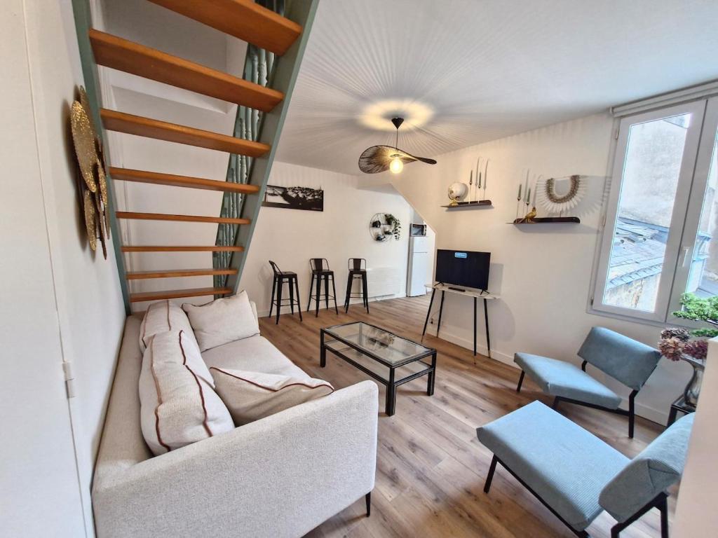 ein Wohnzimmer mit Sofa und Tisch in der Unterkunft Gîte 2 chambres au cœur de la cité médiévale in Guérande