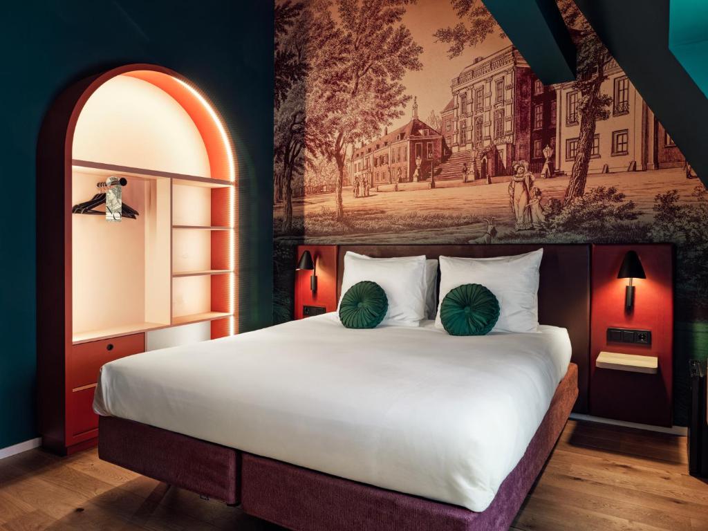 a bedroom with a large bed with a painting on the wall at The ALD Boutique Hotel in The Hague