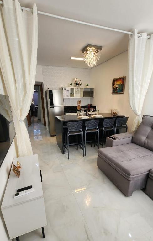 a living room with a couch and a table at Flat Esmeralda Juquehy in São Sebastião