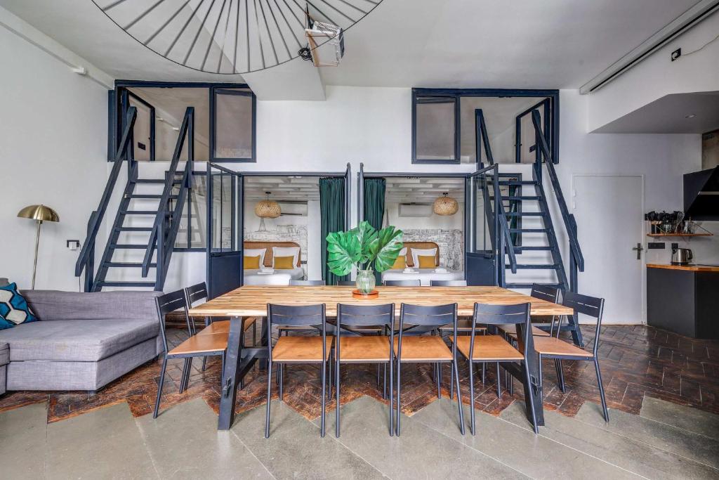 une salle à manger avec une table, des chaises et un canapé dans l'établissement Stylish and sunny 7BD with garden for 17 guests!, à Paris