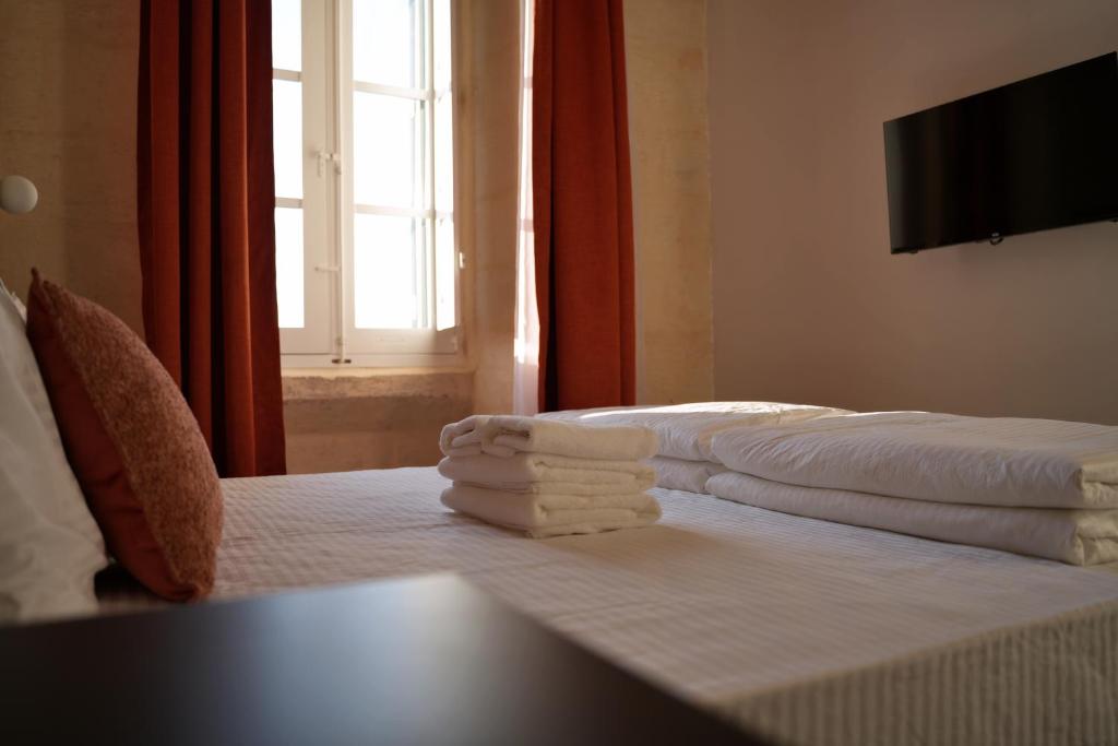 a hotel room with two beds with towels on them at Grand Terrace 4 by Vallettastay in Valletta