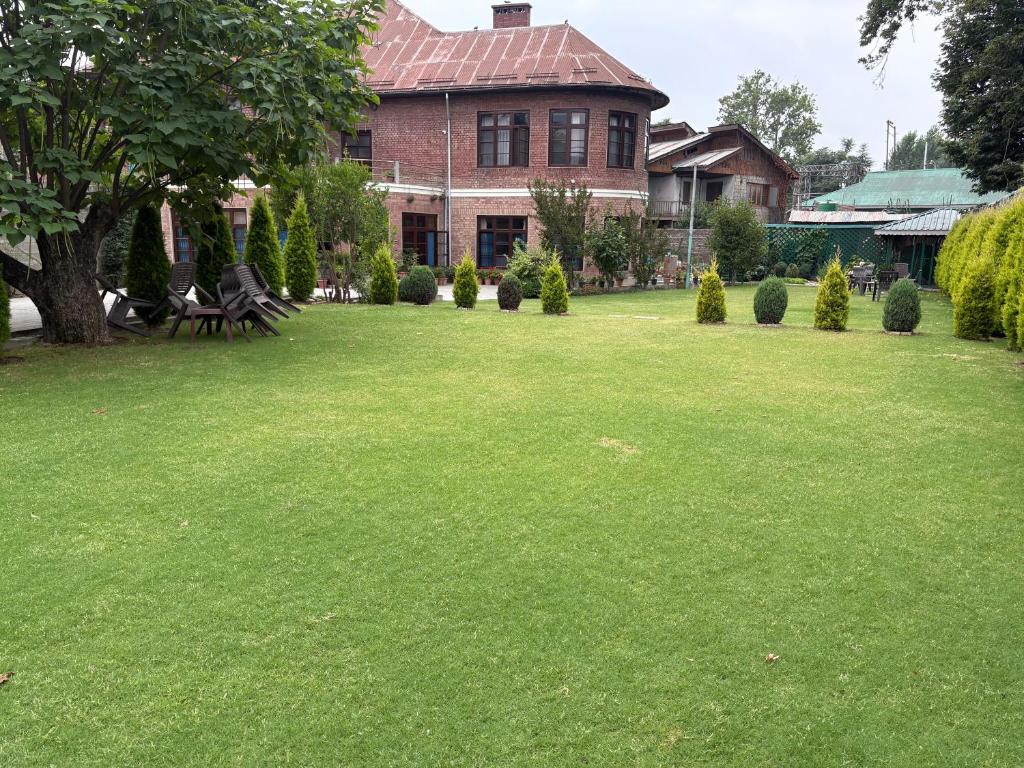 una casa con un ampio giardino con erba verde di Heritage Mansion a Srinagar