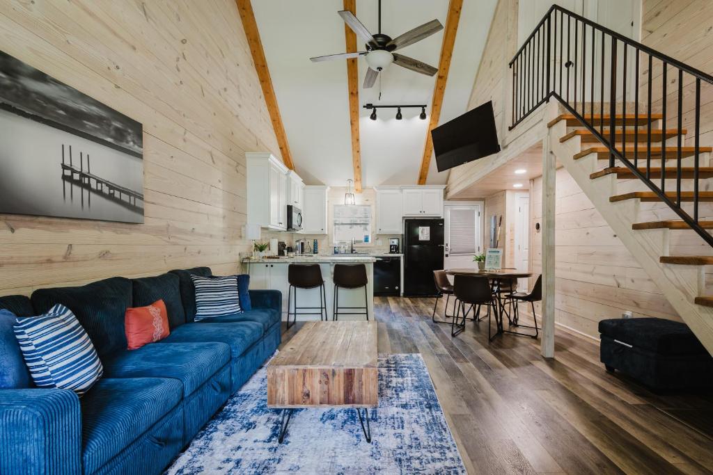 a living room with a blue couch and a kitchen at Relaxing Cabin Retreat with private beach swimming area in Hot Springs