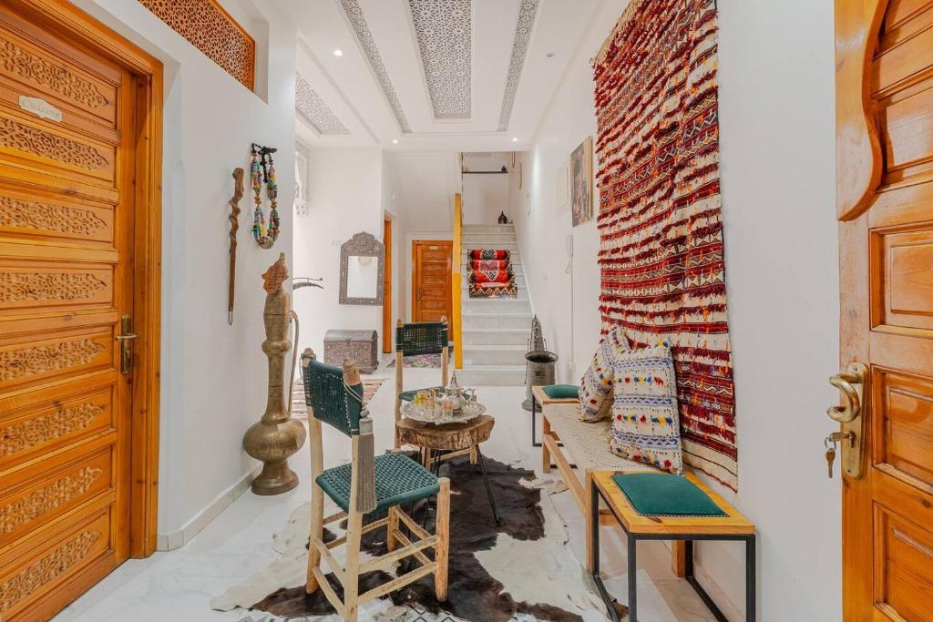un couloir avec des chaises, une table et un mur en briques dans l'établissement RIAD Miel & Une Nuit, à Marrakech