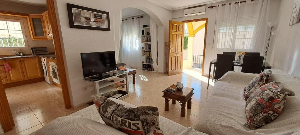 un soggiorno con un divano e una TV di Casa Marrón, Playa Flamenca PF007 a Playa Flamenca