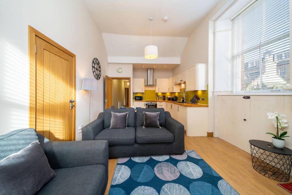 a living room with a couch and a kitchen at Church House in Angus