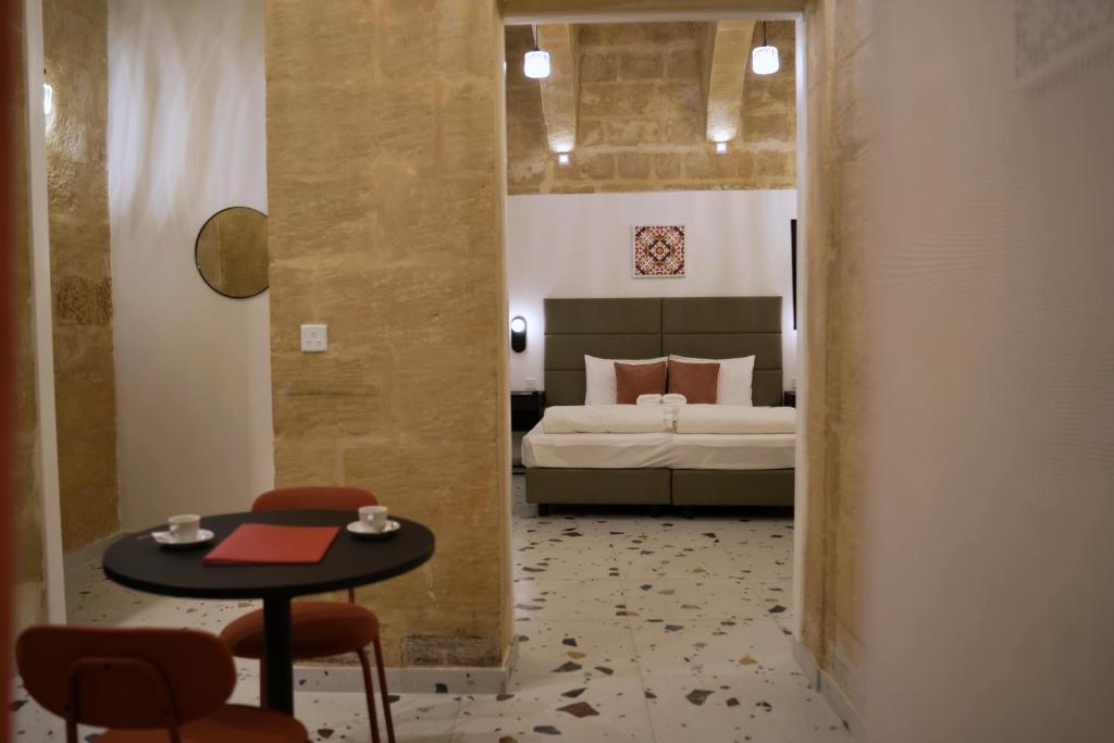 Un dormitorio con una cama y una mesa y una mesa y sillas. en Grand Terrace 2 by Vallettastay, en La Valeta