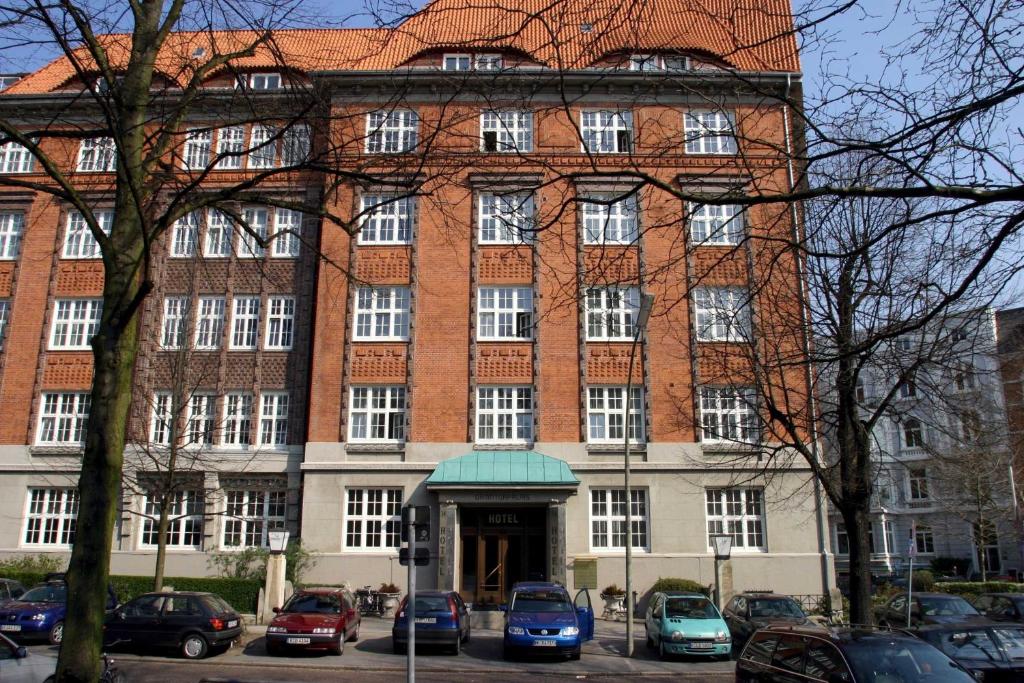 a large brick building with cars parked in front of it at Hotel Bellmoor im Dammtorpalais in Hamburg