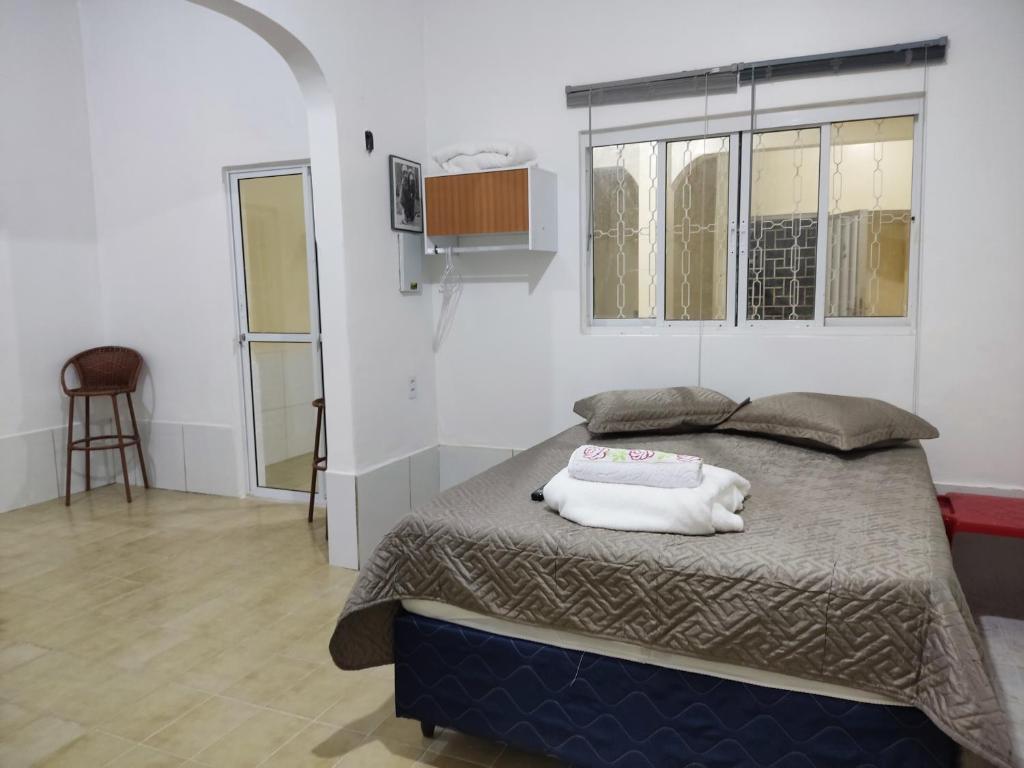 een slaapkamer met een bed met een kussen erop bij Casa próximo centro de eventos com ar condicionado in Fortaleza