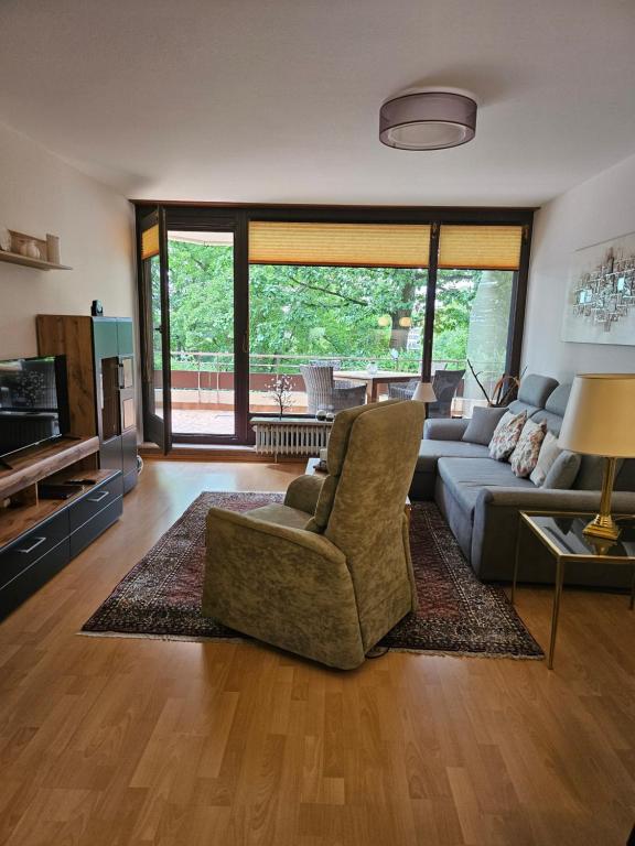 a living room with a couch and a chair at Appartementresidenz am Kurpark Bad Salzuflen in Bad Salzuflen