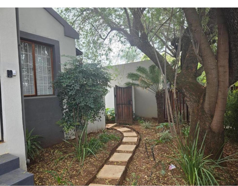 a house with a tree and a wooden door at The Chardonnay Inn in Centurion