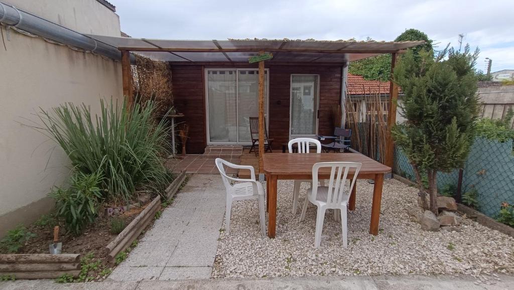 Petit Chalet في سانت كونتان: طاولة وكراسي خشبية على الفناء