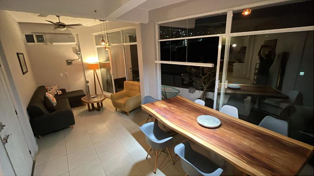 a living room with a table and chairs in a room at Panoramic Paradise 5 min to downtown and beach in Zihuatanejo